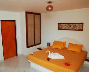 Eva Lanka Hotel - Beach & Wellness في تانجالي: غرفة نوم عليها سرير وبجعة