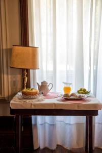 une table avec une lampe et une plaque de fruits sur elle dans l'établissement Casa do Campo - Turismo de Habitação, à Castelbuono