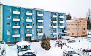 a blue building with snow in a parking lot at Hostel400Kokkola Tehtaankatu in Kokkola