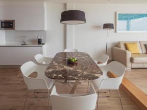 a dining room with a table and white chairs at Flamingo Beach Mate in Adeje