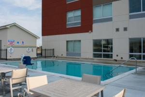 a swimming pool with chairs and a building at Holiday Inn Express & Suites West Memphis, an IHG Hotel in West Memphis