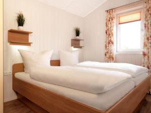 En eller flere senge i et værelse på Dänische Ferienhäuser am Salzhaff Haus Wassermann