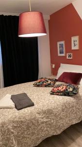 um quarto com uma cama com duas almofadas e um candeeiro em Alojamiento Weier em Valladolid