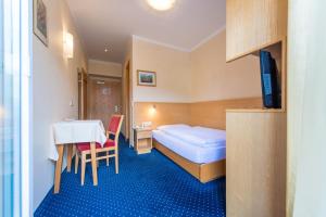 una camera d'albergo con letto e tavolo di Hotel Nocker a Dobbiaco