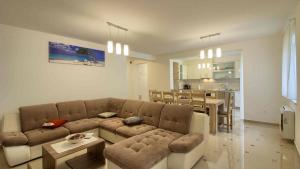 Il comprend un salon avec un canapé brun et une cuisine. dans l'établissement Luxury Vila compelx Mar-Marisol with 2 pools and 8 bedrooms, 200m from the beach, à Banjole
