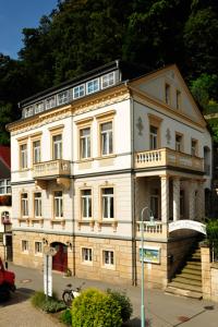 ein großes weißes Gebäude mit Balkon auf einer Straße in der Unterkunft Elbresidenz am Nationalpark in Stadt Wehlen