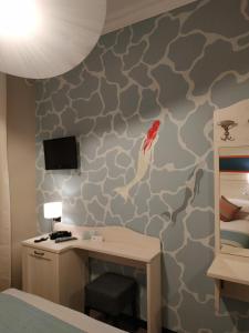 a bedroom with a desk and a wall mural at La Camogliese Hotel B&B in Camogli