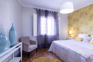 a bedroom with a bed and a chair and a window at Atlantico Apartments in Ribeira Grande +58 photos