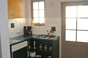 a kitchen with a stove top oven next to a window at Holidayhouse Balie in Bruges