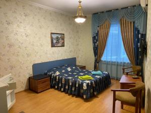 a bedroom with a bed and a table and a window at Hotel Zhemchuzhina in Anapa