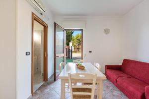 sala de estar con sofá rojo y mesa en Joy Home Apartments by BarbarHouse, en Maruggio
