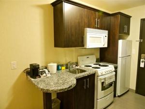 a kitchen with a white stove and a counter top at Western Star Inn and Suites Carlyle in Carlyle