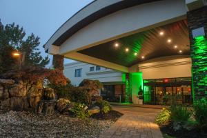 un edificio con luces verdes en el lateral. en Holiday Inn Plainview-Long Island, an IHG Hotel, en Plainview