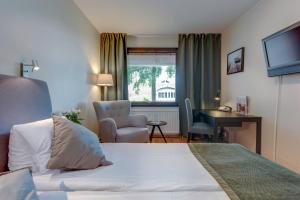 una camera d'albergo con letto, scrivania e sedia di Hotel Bellevue a Hjo