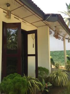 een huis met een deur met uitzicht op de oceaan bij Grandfather Villa in Kosgoda