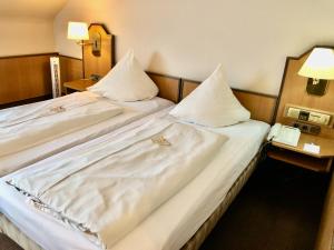 twee bedden in een hotelkamer met een telefoon bij Hotel Central in Frankenthal