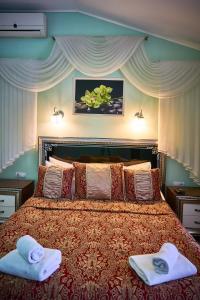 a bedroom with a large bed with towels on it at Двокімнатні апартаменти на Лукіяновича, 3 in Lviv