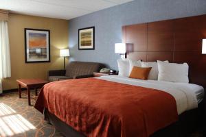a hotel room with a bed, desk, and two lamps at Best Western Plus Fresno Airport Hotel in Fresno