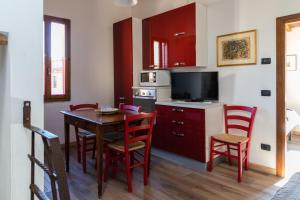 een keuken met een tafel en stoelen en een televisie bij Appartamento Porta Pispini in Siena +17 foto's