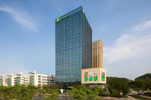 um edifício de vidro alto numa cidade em Holiday Inn Nanjing Harbour, an IHG Hotel em Nanquim