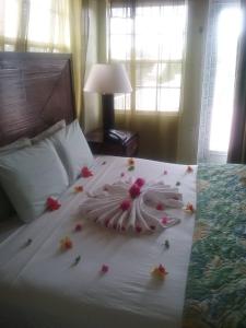 Una cama con una flor hecha de flores. en Aanola Villas 6b Tranquil Privy Boudoir en Charlotte