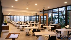 a cafeteria with tables and chairs and windows at Nite & Day MDC Puncak - Gadog in Bogor