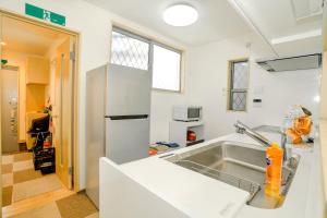 uma cozinha com um lavatório e um frigorífico em Zenith's House em Osaka