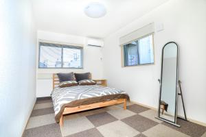 a bedroom with a bed and a mirror at Zenith's House in Osaka