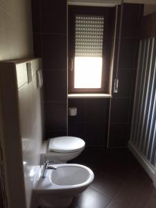 a bathroom with a toilet and a sink and a window at Il Falco e Il Gabbiano in Corigliano Calabro