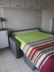 a bed with a colorful blanket on it in a room at STUDIO PORT VAUBAN excellente situation climatisé Box Fibre in Antibes
