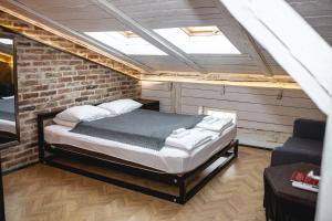 sypialnia z łóżkiem w ceglanej ścianie w obiekcie Vysoka Khata 4 w Lwowie