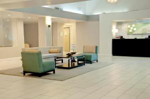 a lobby with two chairs and a couch and a table at Holiday Inn Victorville, an IHG Hotel in Victorville