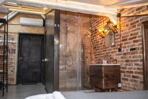 łazienka z prysznicem, umywalką i drzwiami w obiekcie Vysoka Khata 4 w Lwowie