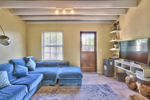 sala de estar con sofá azul y TV de pantalla plana en Milton mews, en Ciudad del Cabo