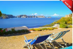duas cadeiras sentadas numa praia com vista para a água em Maridea - Les Suites Du Soleil em Ponza