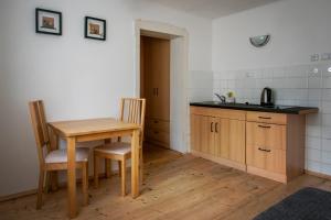 a kitchen with a wooden table and a table and chairs at Pension Styl in Bedřichov