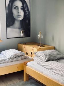 Pokój z dwoma łóżkami i zdjęciem kobiety w obiekcie Gospodarstwo Agroturystyczne „Betula Pendula” Duży Dom w mieście Drzewica