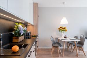 a kitchen with a table and chairs and a dining room at Art Apart nad Oławą Wrocław in Wrocław