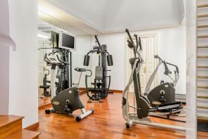 a gym with several treadmills and exercise bikes at Eurostars Centrale Palace Hotel in Palermo