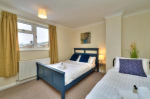 a bedroom with two beds and a window at Hampson House Stevenage by PAY AS U STAY in Stevenage