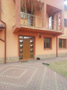 - un bâtiment avec une porte en bois et un balcon dans l'établissement Vila Mario, à Galaţi