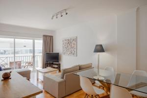 a living room with a couch and a table at Monte Gordo Beach Flat with Balcony in Monte Gordo
