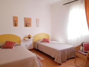 Cette chambre dispose de deux lits, d'une chaise et d'une fenêtre. dans l'établissement Casa Camino Tamadaba, à Agaete