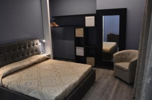 ein Schlafzimmer mit einem Bett, einem Stuhl und einem Spiegel in der Unterkunft Luxury Bellevue Centro Città in Pescara