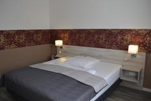 ein Schlafzimmer mit einem Bett mit zwei Lichtern an der Wand in der Unterkunft Hotel-Café-Galerie in Garbsen
