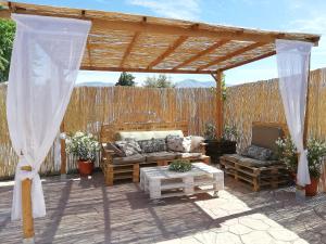 pérgola de madera con sofá y mesa en Cortijo los Dolmenes, en Antequera