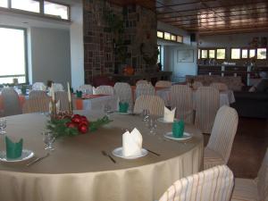a dining room with a round table with white chairs at Chrissa Camping Rooms & Bungalows in Delphi