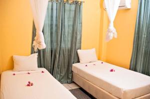 two beds in a room with flowers on them at Aanola Villas A5 Hushed Hacienda in Charlotte
