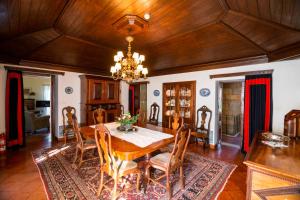 a dining room with a table and a chandelier at Casa das Paredes in Fafe