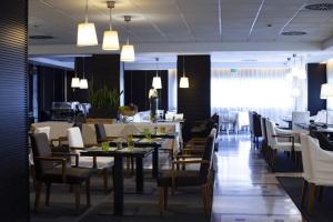 un comedor con mesas y sillas y un restaurante en BV Hotel Oly en Roma